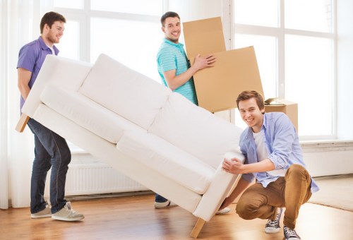 Professional team collecting old sofas and chairs in Queenspark