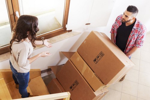 Packed moving boxes and furniture ready for transport in Queens Park